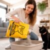 Mujer vertiendo arena mineral para gatos Mi Mascota Feliz en la bandeja sanitaria junto a gato negro