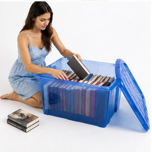 Joven organizando prendas de vestir en una caja de almacenamiento azul translúcida de MegaSharkCo.