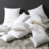 Variedad de rellenos de cojín decorativos de diferentes formas y tamaños ordenados sobre una cama.