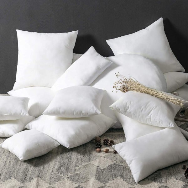 Variedad de rellenos de cojín decorativos de diferentes formas y tamaños ordenados sobre una cama.