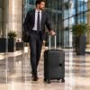 Hombre con traje formal desplazandose por la terminal con maleta de mano elegante negra MegaShark