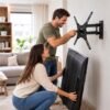 Persona instalando un soporte de pared articulado para televisión en el salón de casa